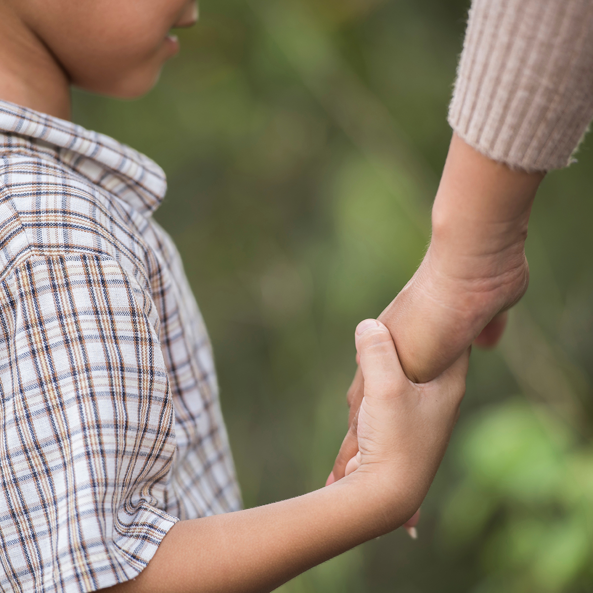 child holding hands with an adult