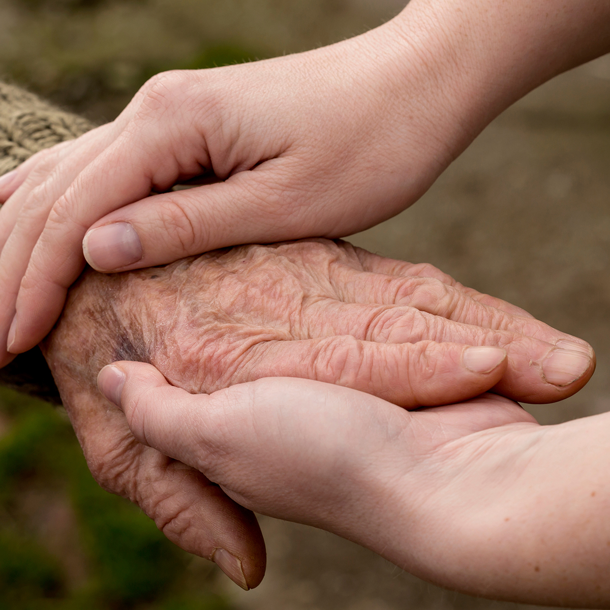 hands holding the hand of a senior man in comfort